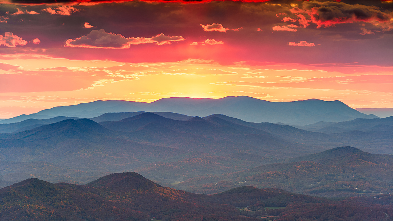 The sun sets in layers of red, orange and yellow over the Blue Ridge Mountains at Brasstown Bald, Georgia's highest point. 