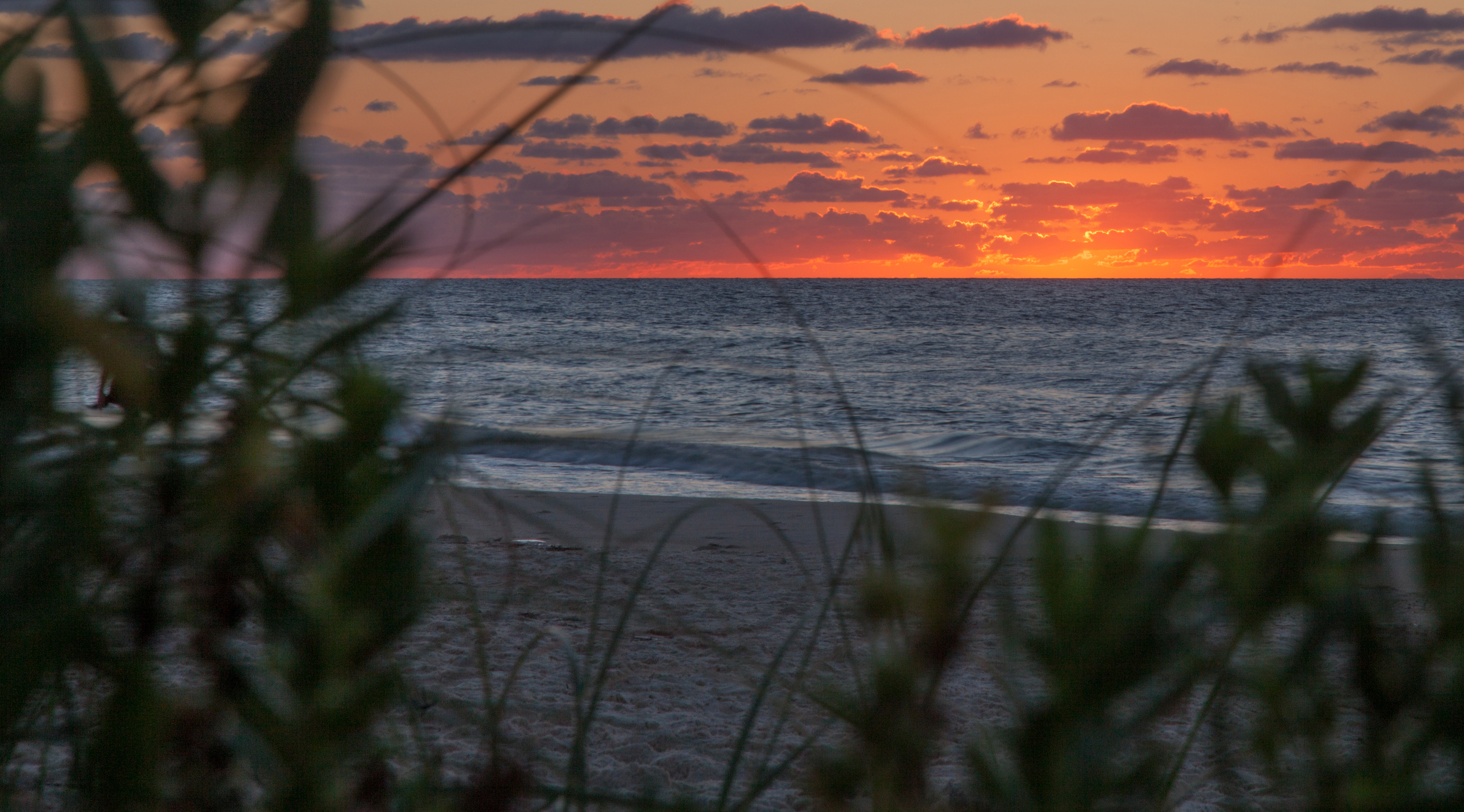 The sun sets over the ocean at St. George Island in Florida. 
