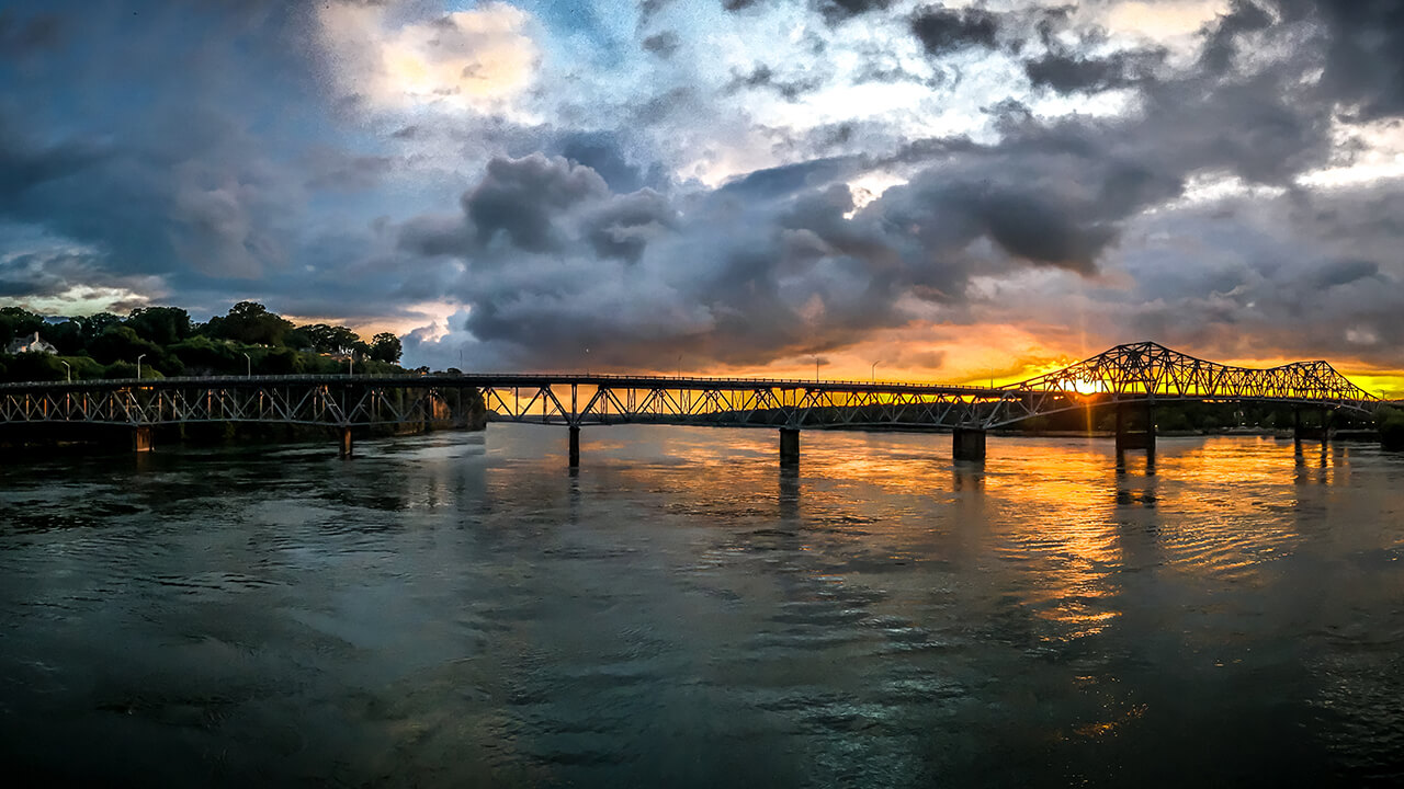 The sun sets over the Tennessee River and Old Railroad Bridge in Florence.
