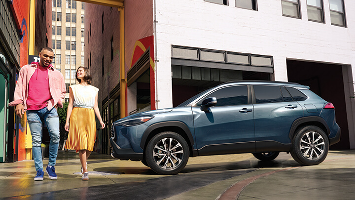 Couple walking in front of 2022 Toyota Corolla Cross