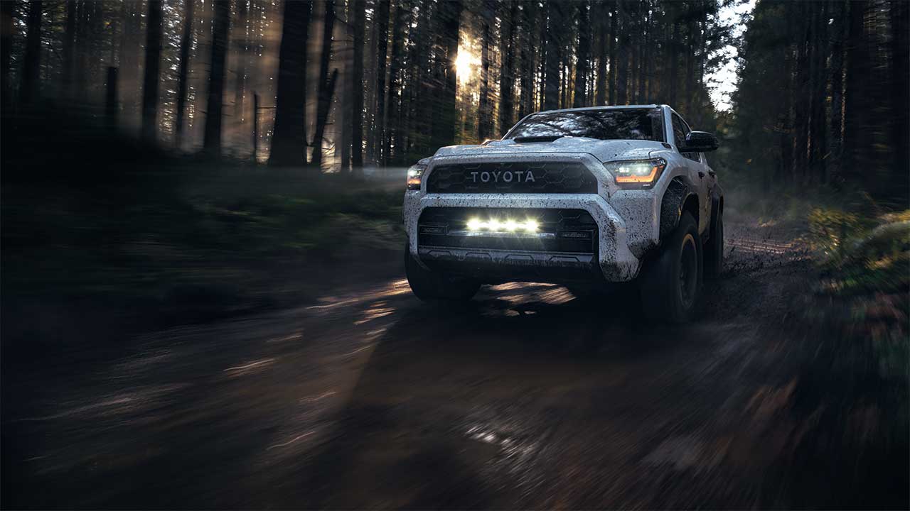 2025 Toyota 4Runner off road in a drak forest with closeup of the front grill