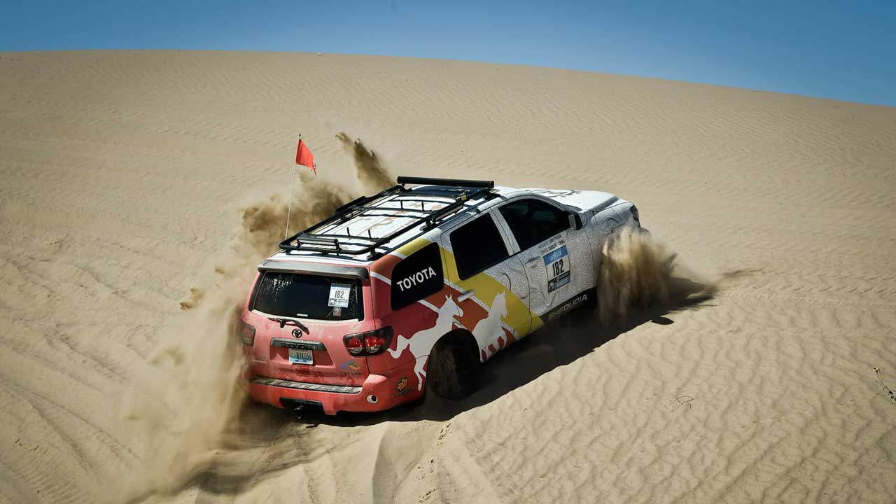 Toyota 4Runner climbing a steep desert dune