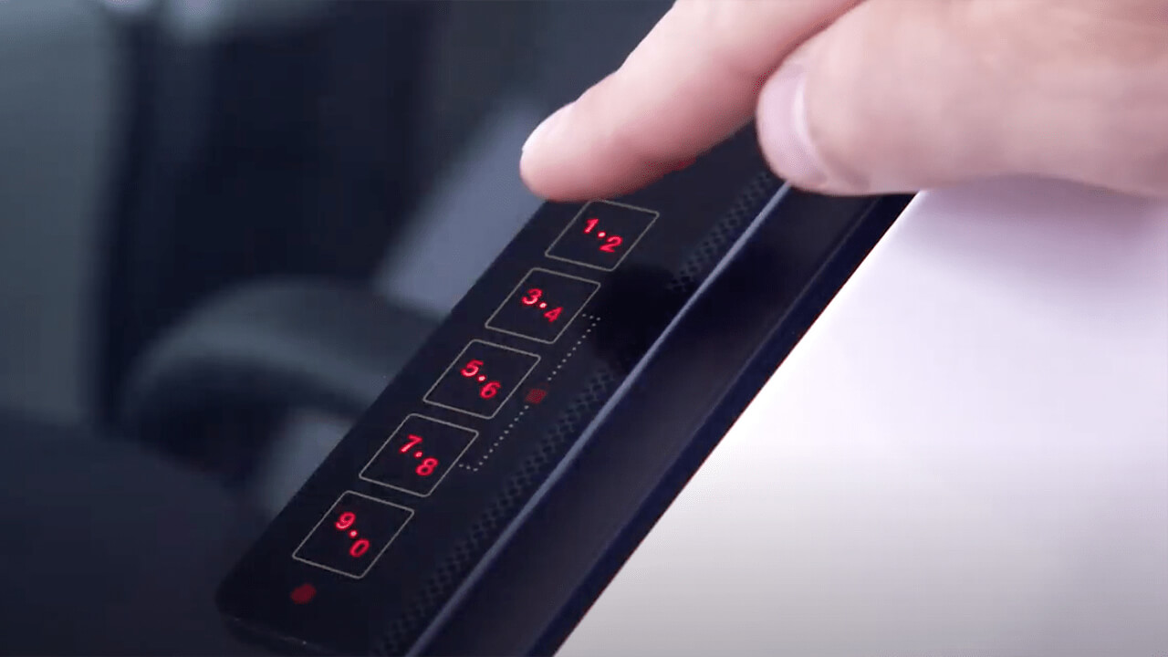 A finger hovers over the Touch Keypad on the windshield of a Toyota. 