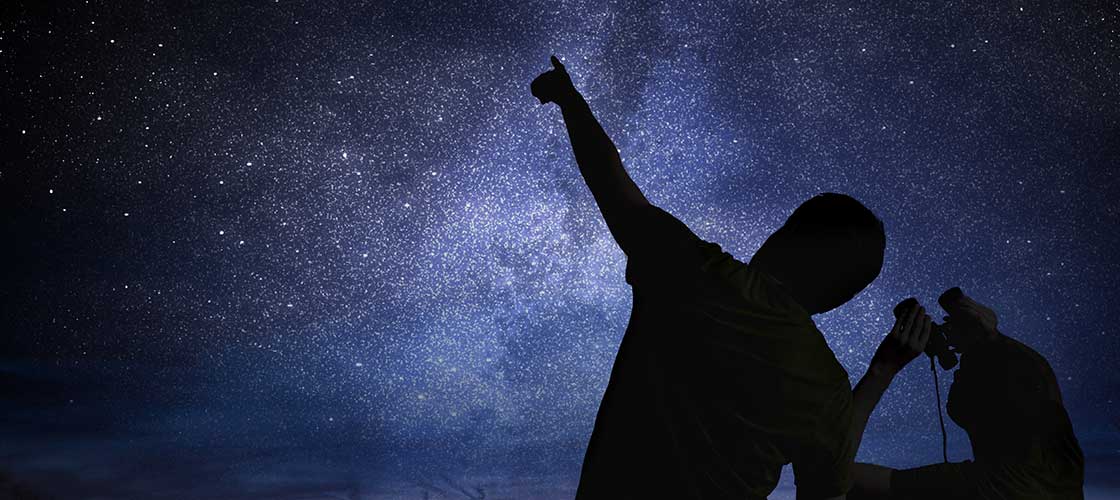 A Couple pointing out stars in a starry night