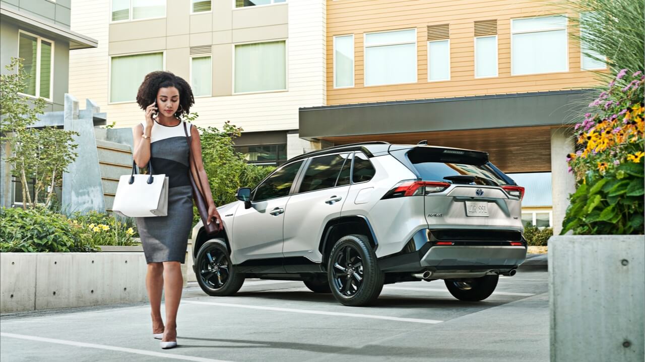 2019 RAV4 with well dressed woman on phone walking away