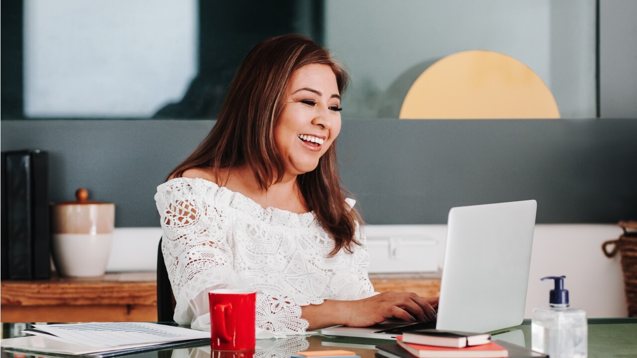 Happy woman on computer at her desk