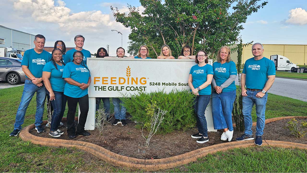 Associates next to Feeding The Gulf Coast Banner