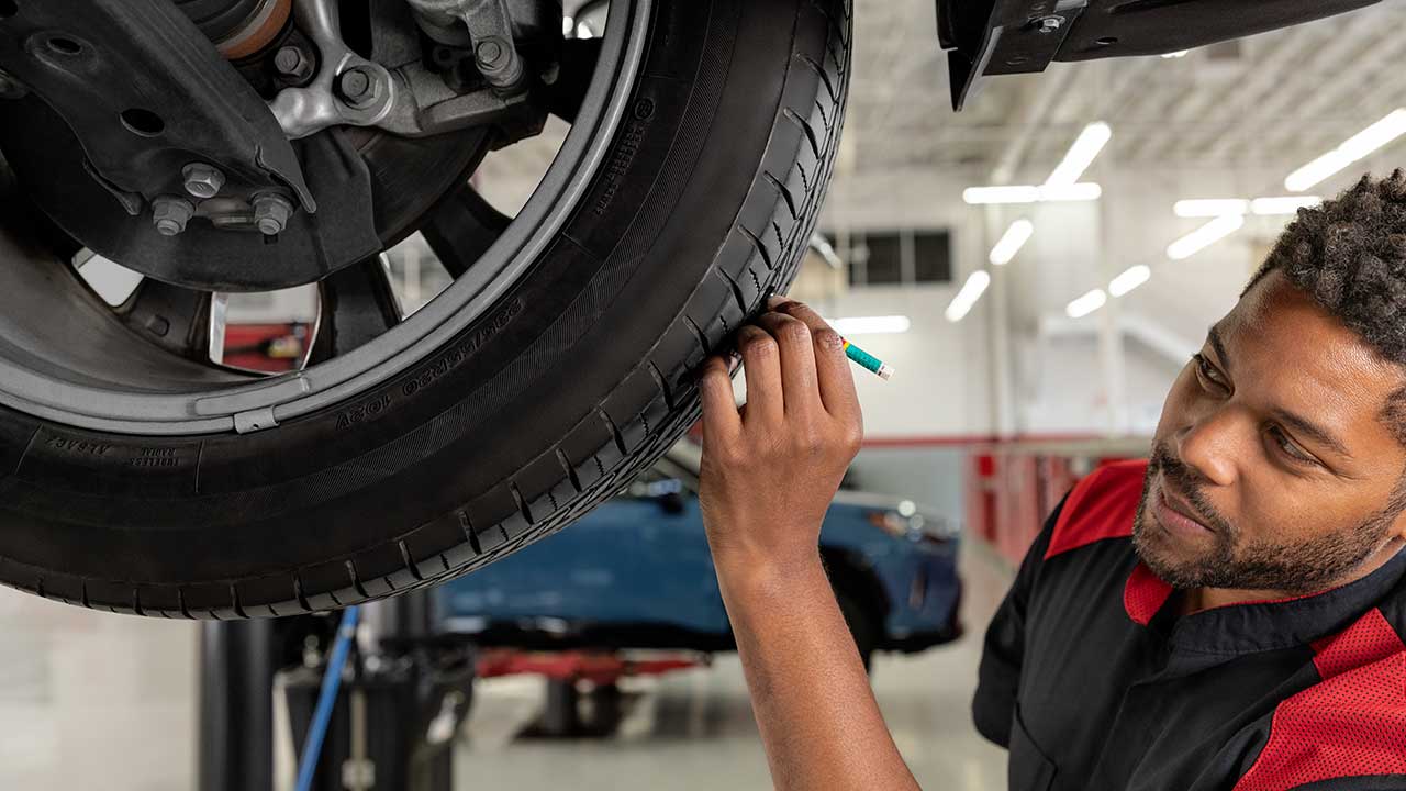 Service person checking tire tread