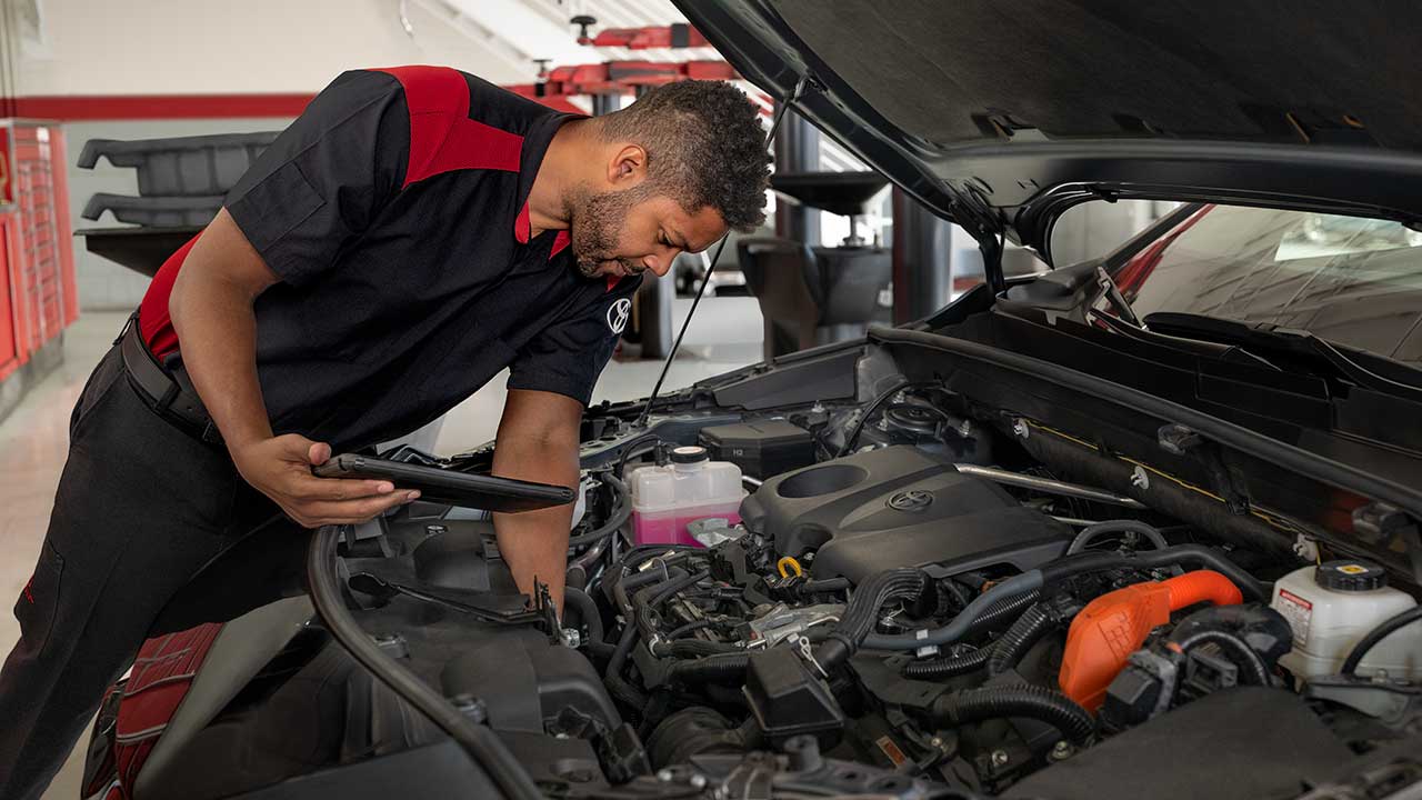 Service Tech looking under the hood of a Toyota