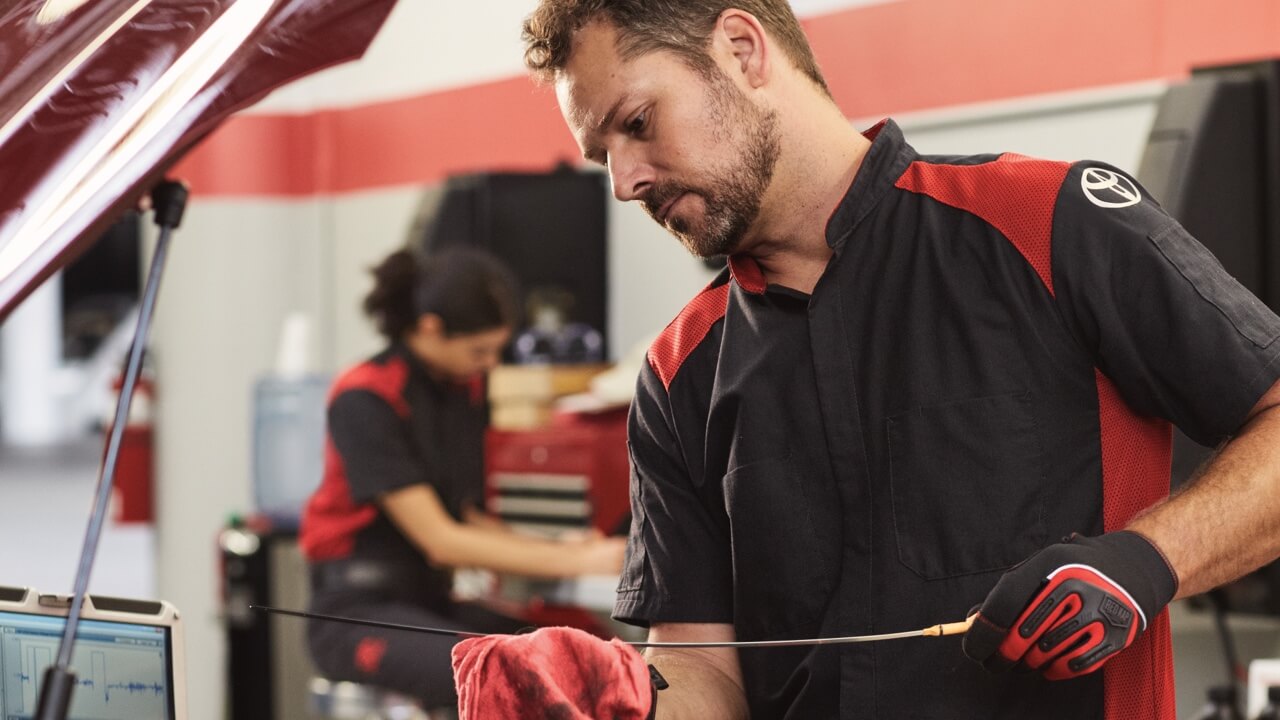 Toyota technician checking oil
